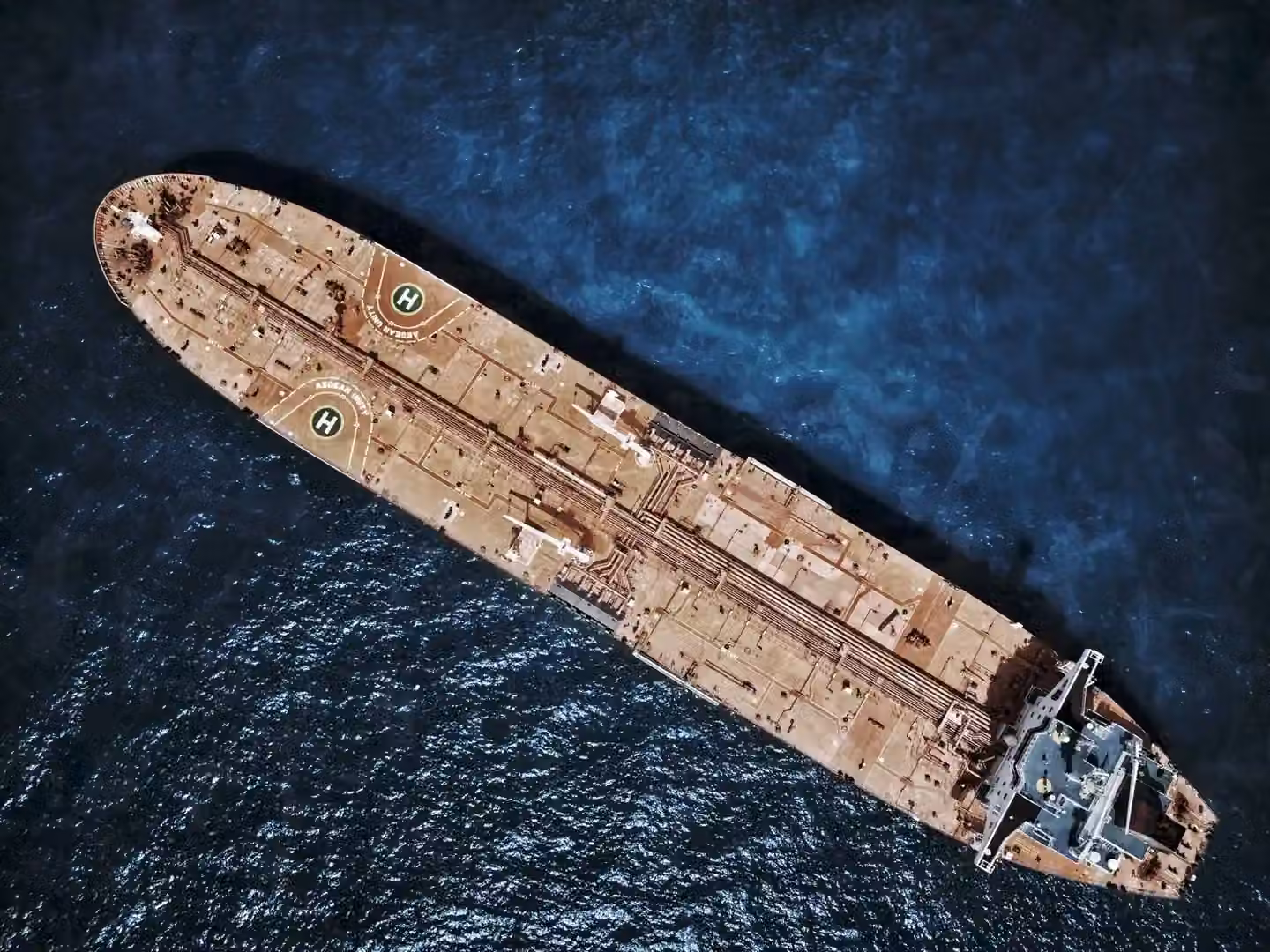 Drone shot of large tanker ship with helipads in ocean waters.