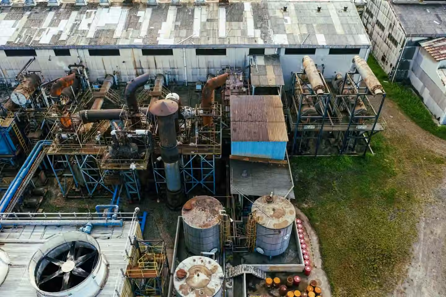 Drone view of industrial area with barrels for petroleum products and pipes connected with warehouses